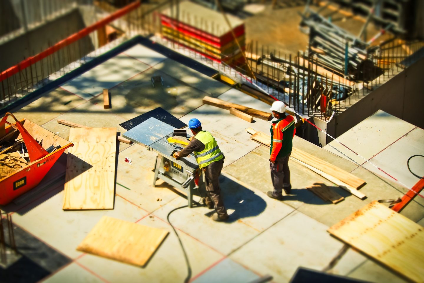 Construction workers cutting plywood