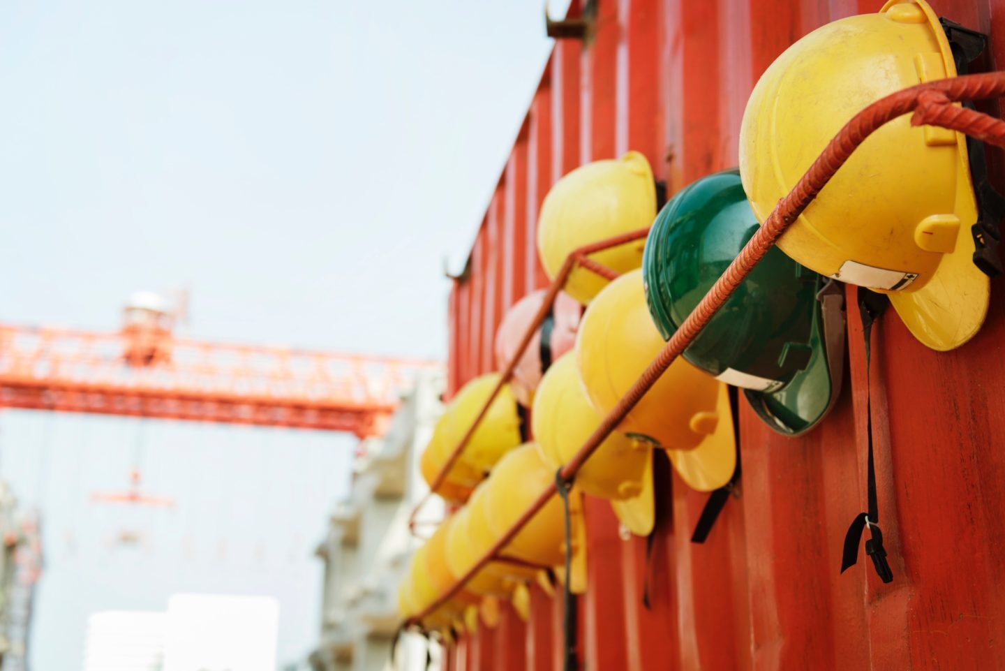 Row of hard hats, one green and several yellow