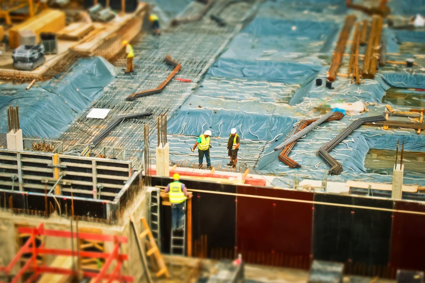 Construction worker in yellow safety climbing on ladder